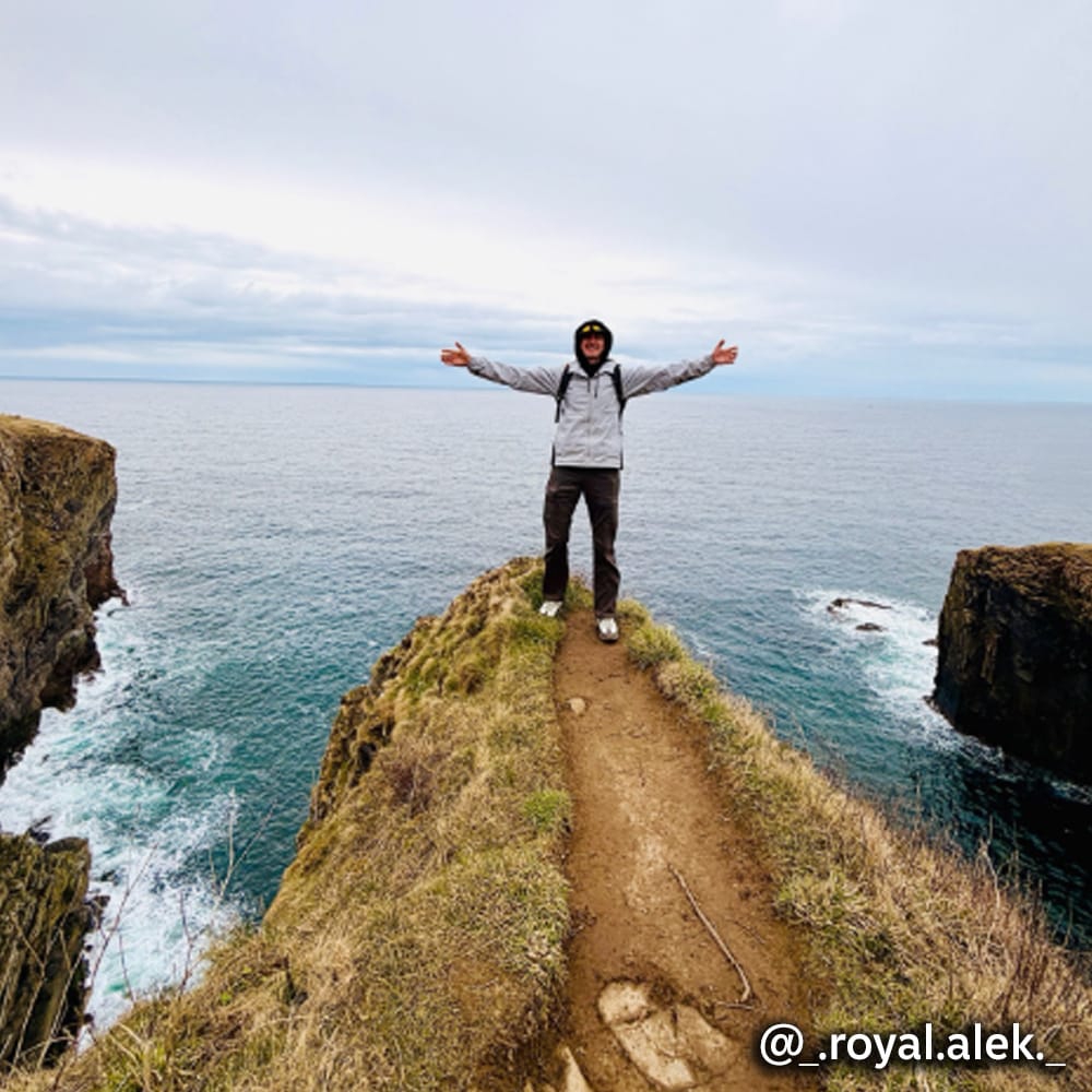 A man standing by the ocean @_.royal.alek._. Super Shoes Instagram.
