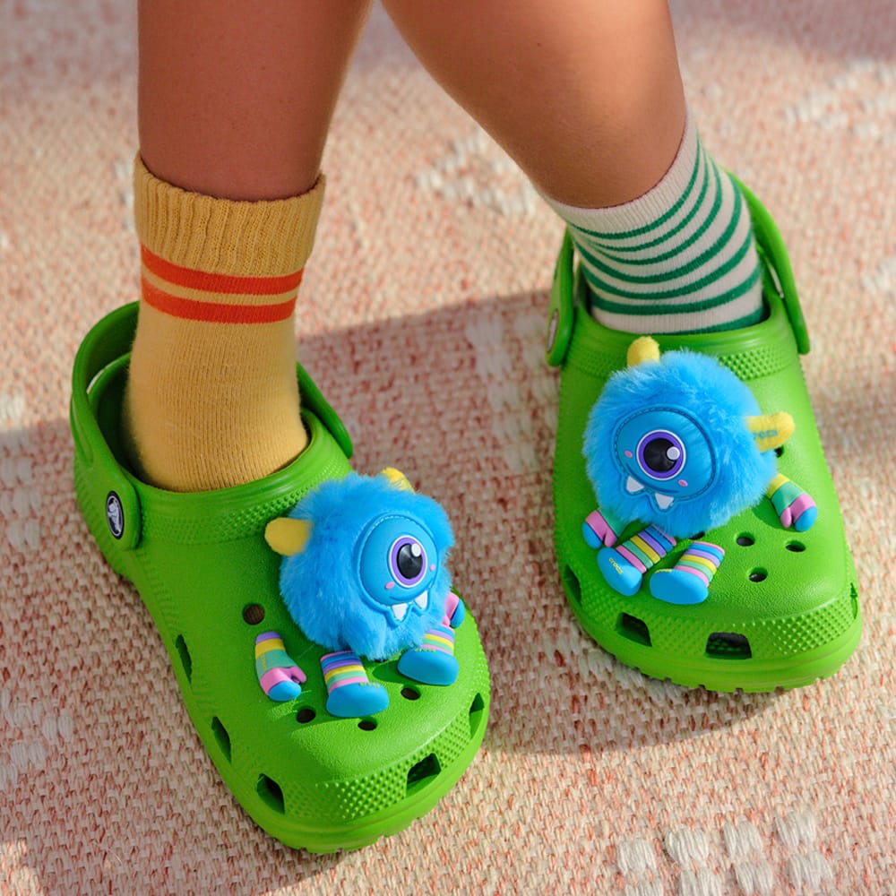 A child wearing a pair of green Croc clogs.