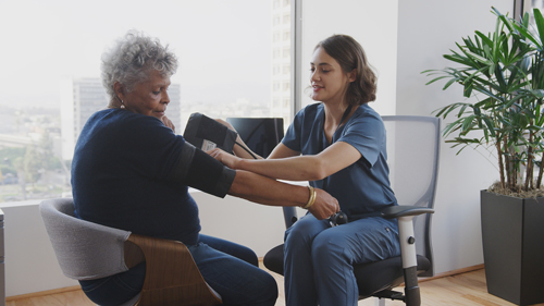 Nurse taking a woman's blood pressure.